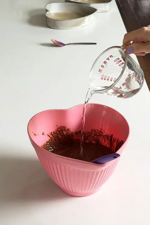 Adding hot water to the cake batter.