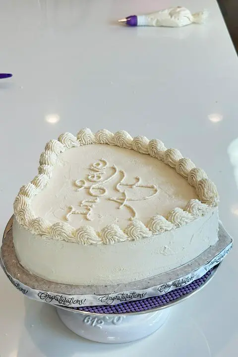 piping shell borders on the heart cake.