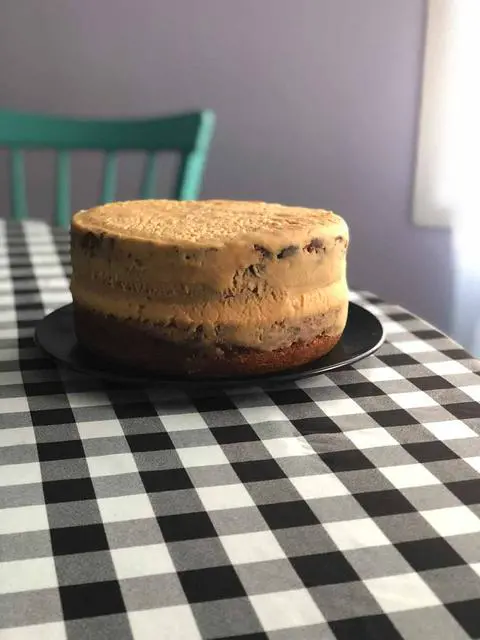 frosting the vegan banana peanut butter cake with a crumb coat
