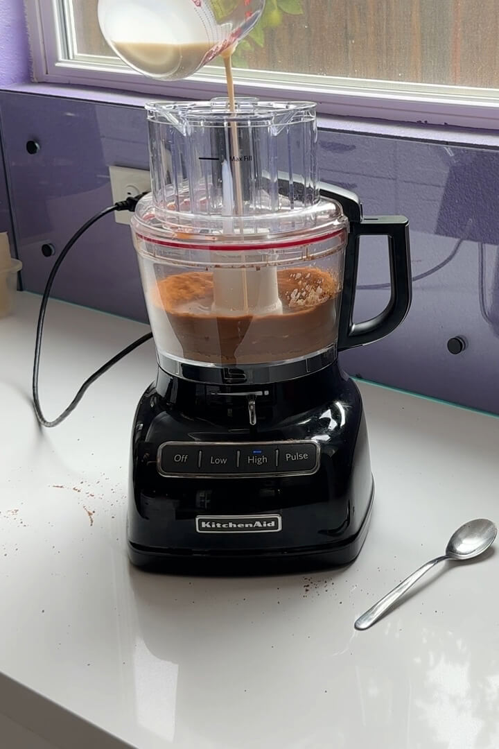 drizzling vegan creamer into the biscoff cookie crumbs while the food processor is running.