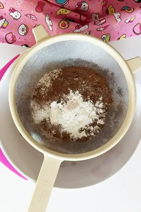 sifting dry ingredients into the wet ingredients.