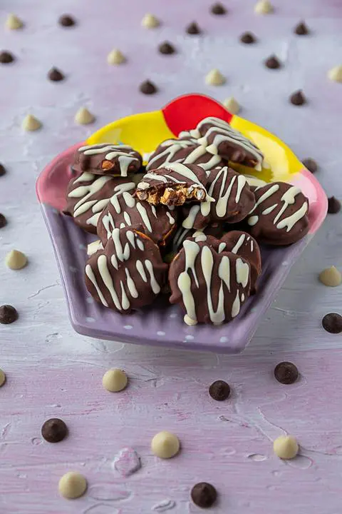 vegan dark and white chocolate peanut butter pretzels with a bite taken out of one