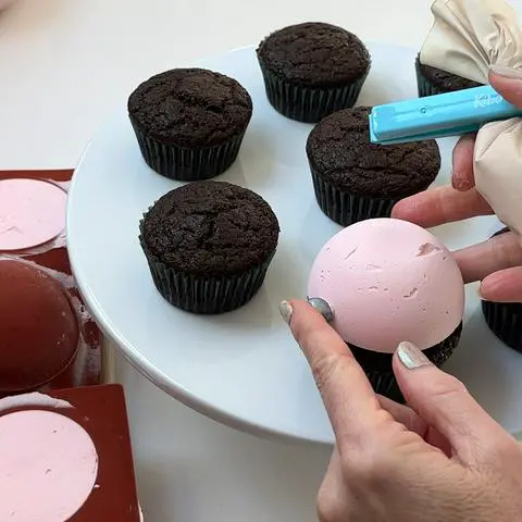 pressing the painted marshmallow onto the ornament frosting.