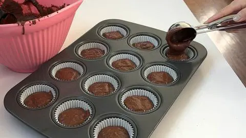 filling the cupcake pan with vegan chocolate cupcake batter.