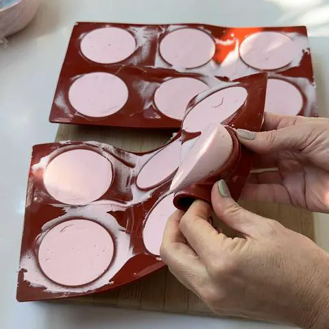 popping the vegan frosting out of the molds.