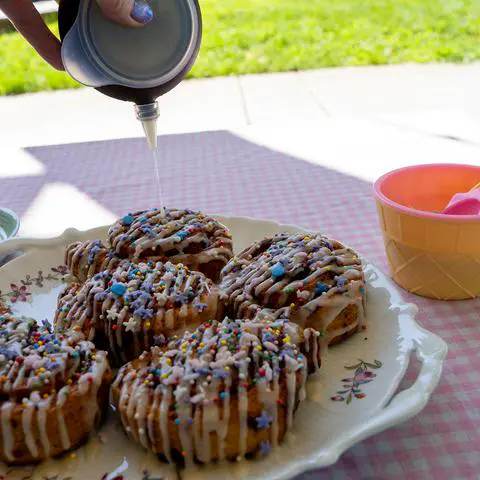 adding icing to cinnamon rolls using a decopen.