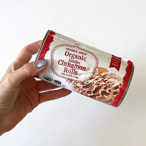 holding a can of Trader Joe’s brand cinnamon rolls.