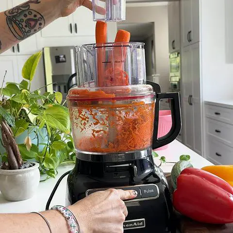 using a food processor to quickly grate the carrots.