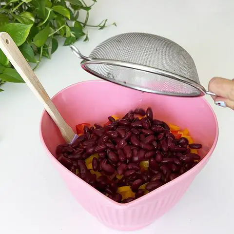adding kidney beans to the couscous salad.