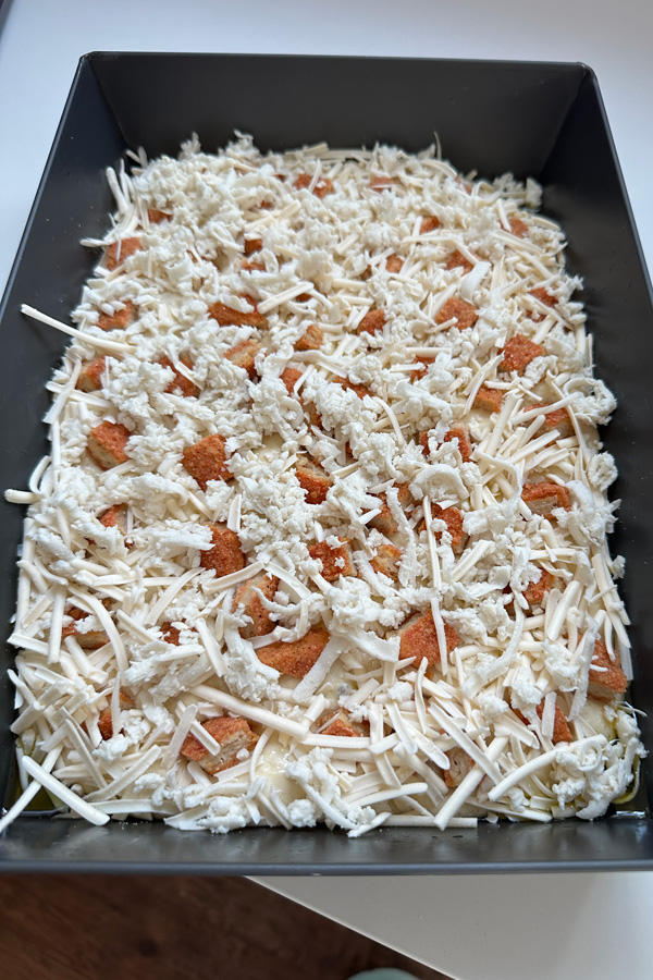 covering the pizza in vegan grated mozzarella