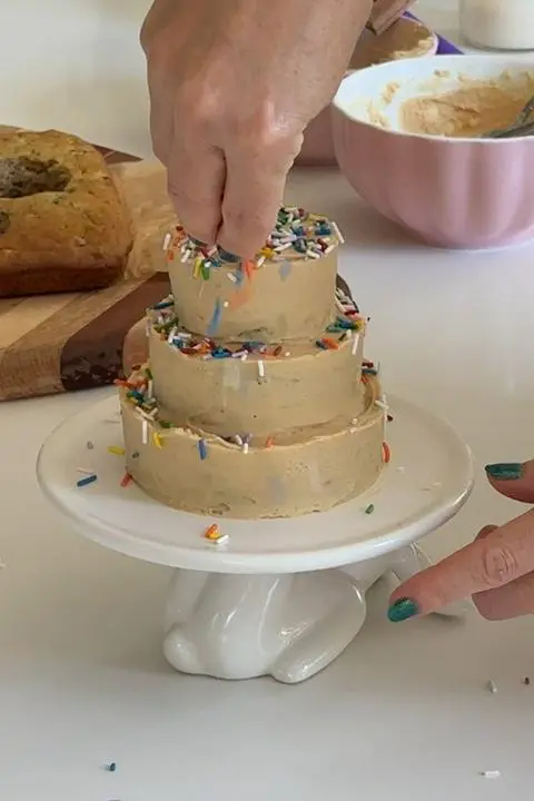 adding sprinkles to the dog cake.