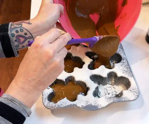 pouring batter into each cubby of the pan.