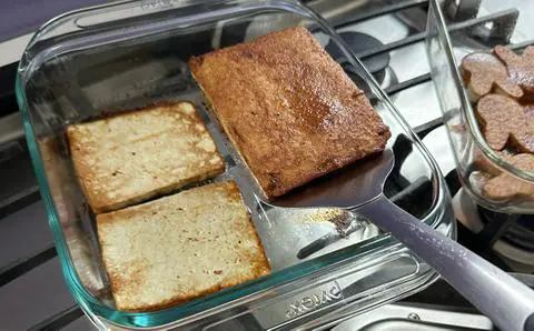 flipping the vegan ham slices halfway through the baking