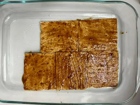 tofu ham covered in ham seasoning marinade and ready to bake