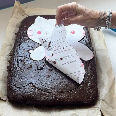 peeling the template off of the vegan cake.