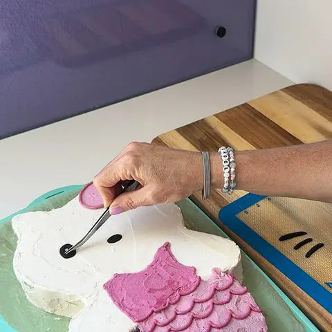 placing the chocolate eye onto the cake with tweezers.