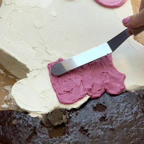 smoothing out hello kitty’s shirt with a small offset spatula.