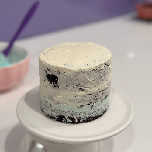 mini vegan chocolate birthday cake covered in a crumb coat of frosting