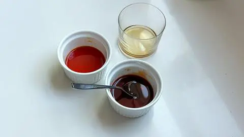 3 bowls of rice vinegar: one plain, one colored yellow, and one colored orange.