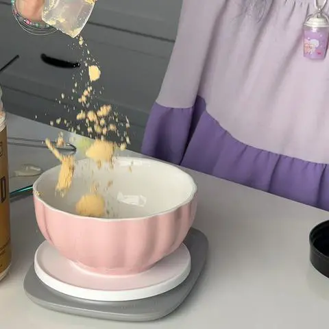 measuring peanut butter powder into a bowl.