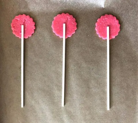 pressing the lollipop sticks into the bottom crust