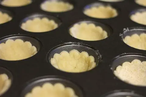 mini muffin pan filled with vegan cookie pie crust