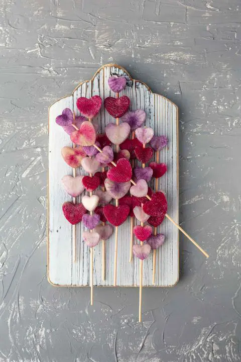 threading the radish hearts onto bamboo skewers