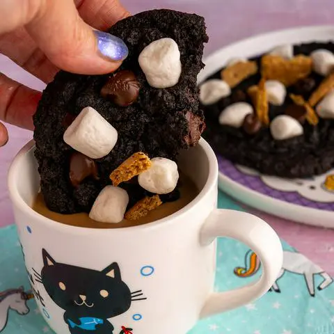 dunking half a vegan s’mores cookie into coffee.