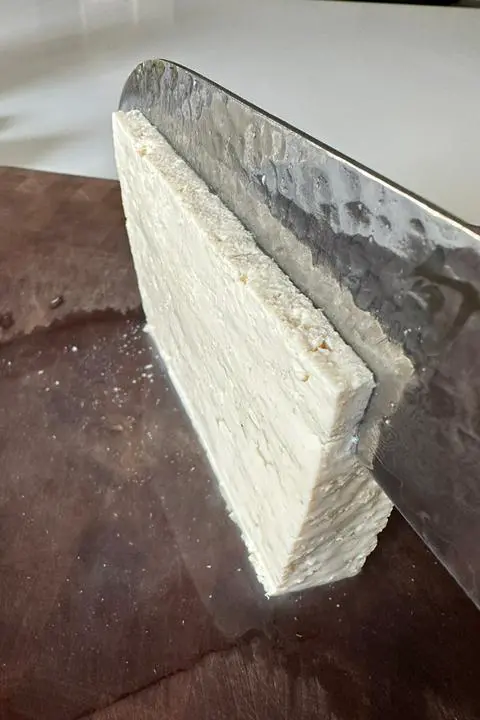 slicing tofu to make vegan spam