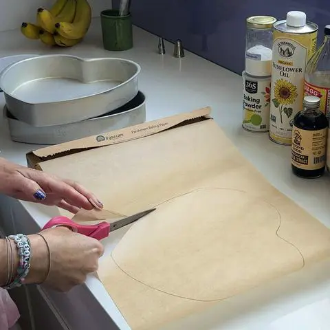 cutting the shape I traced on the parchment paper using pink scissors.