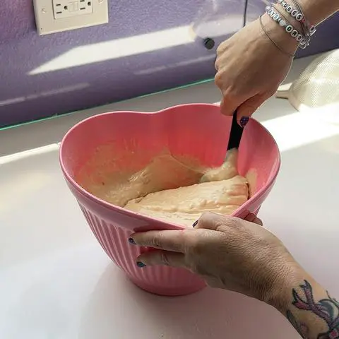 mixing the vanilla cake batter with a baking spatula.