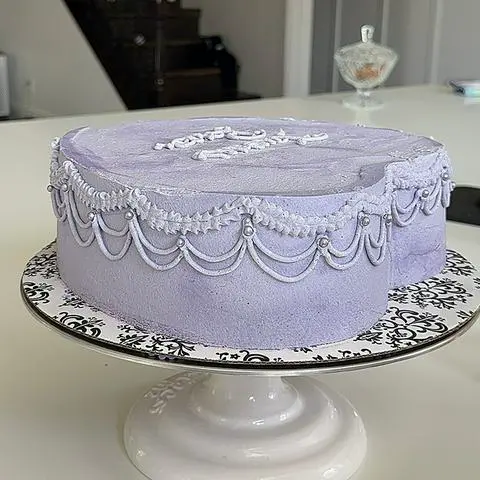 side of cake with pearls added at the top of all the drop strings.