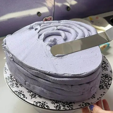 smoothing out the frosting with an offset spatula.