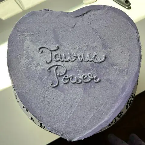 the heart cake with Taurus Power written on top in frosting.