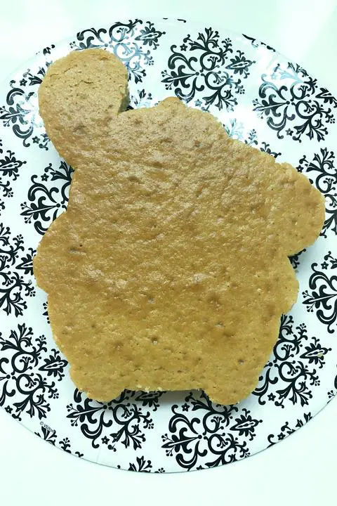 the bottom layer of the vegan vanilla pompompurin shaped cake on a cake board